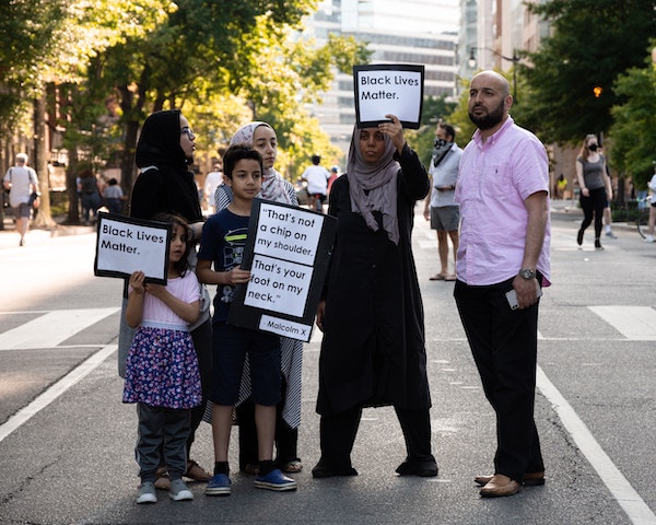 A family protests peacefully with signs readying "Black Lives Matter."